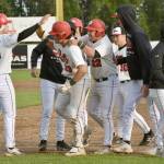 Peninsula Oilers catcher Braden Smith (23) gets congratulations from Cody New (26) on Monday, July 29, 2024, at Coral Seymour Memorial Park in Kenai, Alaska. Smith drove in New for the game-winning run in the bottom of the 10th inning. (Photo by Jeff Helminiak/Peninsula Clarion)