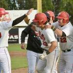 Peninsula Oilers catcher Braden Smith (23) gets congratulations from Cody New (26) on Monday, July 29, 2024, at Coral Seymour Memorial Park in Kenai, Alaska. Smith drove in New for the game-winning run in the bottom of the 10th inning. (Photo by Jeff Helminiak/Peninsula Clarion)