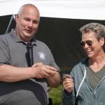North Peninsula Recreation Service Area Director Eric Eleton gives a commerative coin to past Director Rachel Parra during a celebration of the 50th anniversary of North Peninsula Recreation Service Area at the Nikiski Pool in Nikiski, Alaska, on Saturday, Aug. 3, 2024. (Jake Dye/Peninsula Clarion)