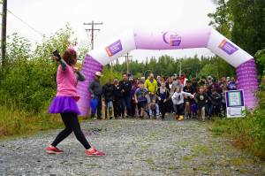 Organizer Alana Martin looses the racers for the Brewery to Bathroom .5K The Race for the Rest of Us at Kenai River Brewing in Soldotna, Alaska, on Saturday, Aug. 11, 2024. (Jake Dye/Peninsula Clarion)