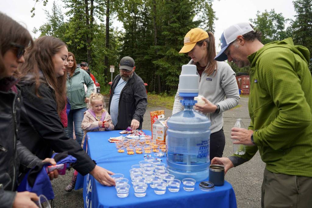 The Kenai Watershed Forums Sara Aamodt and Trenten Dodson serve water and snacks at the rehydration station during the Brewery to Bathroom .5K The Race for the Rest of Us at Kenai River Brewing in Soldotna, Alaska, on Saturday, Aug. 11, 2024. (Jake Dye/Peninsula Clarion)