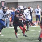 Kenai Centrals Bobby Hayes rushes the ball against Homer on Saturday, Aug. 17, 2024, at Ed Hollier Field at Kenai Central High School in Kenai, Alaska. (Photo by Jeff Helminiak/Peninsula Clarion)