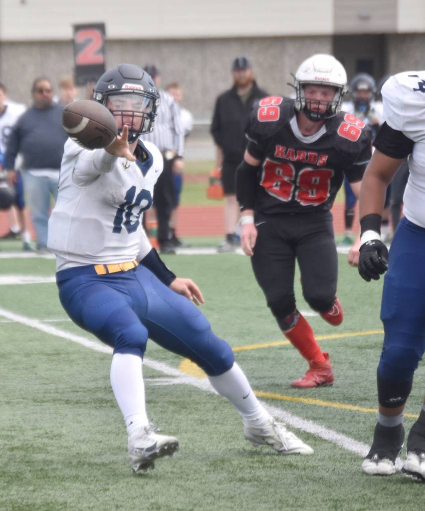 Homer quarterback Preston Stanislaw pitches the ball to running back Justus Grimes on Saturday, Aug. 17, 2024, at Ed Hollier Field at Kenai Central High School in Kenai, Alaska. (Photo by Jeff Helminiak/Peninsula Clarion)