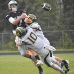 Nikiskis Ethan Ellis passes under pressure from Sewards Ronan Bickling and Emerson Cross (10) on Saturday, Aug. 17, 2024, at Nikiski Middle-High School in Nikiski, Alaska. (Photo by Jeff Helminiak/Peninsula Clarion)