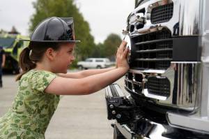 Briar Oden is the first to start pushing a new ambulance into the garage at the Kenai Public Safety Building in Kenai, Alaska, on Saturday, Aug. 17, 2024. (Jake Dye/Peninsula Clarion)