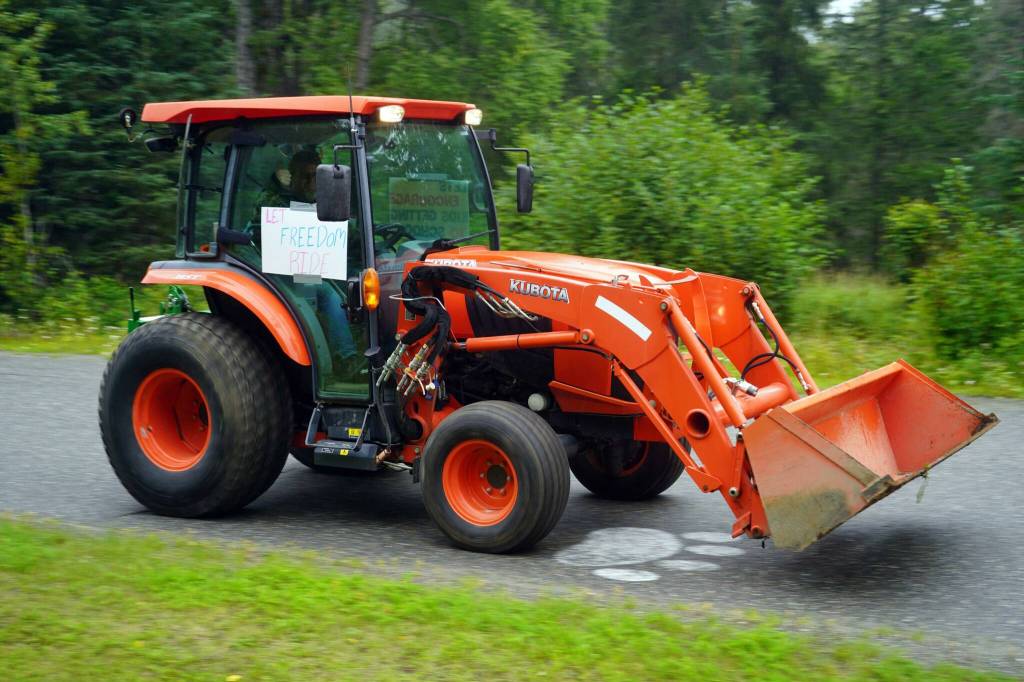 The Community Ride for Parking Policy Change rolls up the driveway of Nikiski Middle/High School in Nikiski, Alaska, on Saturday, Aug. 17, 2024. (Jake Dye/Peninsula Clarion)