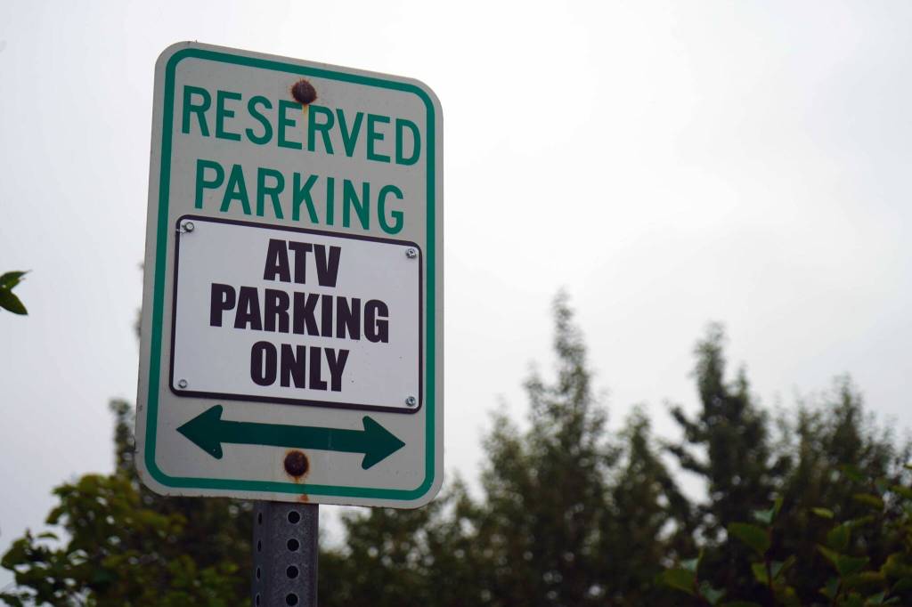 A sign designates an area for ATV parking at Nikiski Middle/High School in Nikiski, Alaska, on Saturday, Aug. 17, 2024. (Jake Dye/Peninsula Clarion)