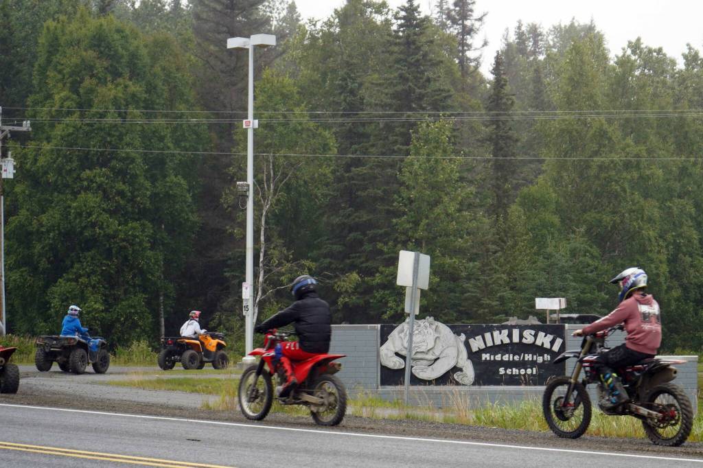 The Community Ride for Parking Policy Change rolls up the driveway of Nikiski Middle/High School in Nikiski, Alaska, on Saturday, Aug. 17, 2024. (Jake Dye/Peninsula Clarion)