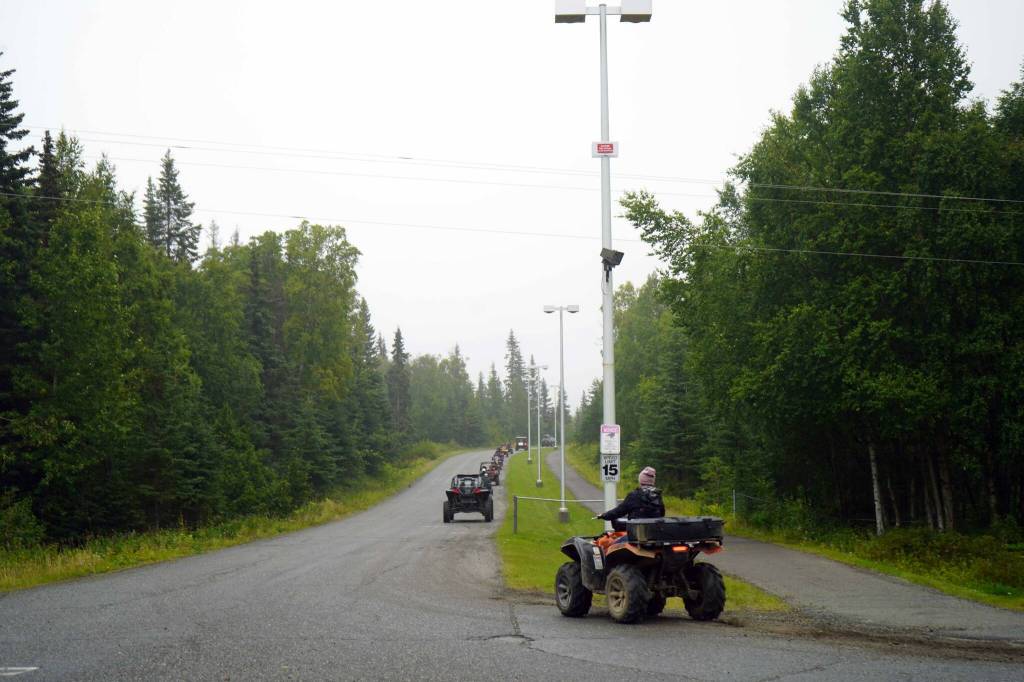 The Community Ride for Parking Policy Change rolls up the driveway of Nikiski Middle/High School in Nikiski, Alaska, on Saturday, Aug. 17, 2024. (Jake Dye/Peninsula Clarion)