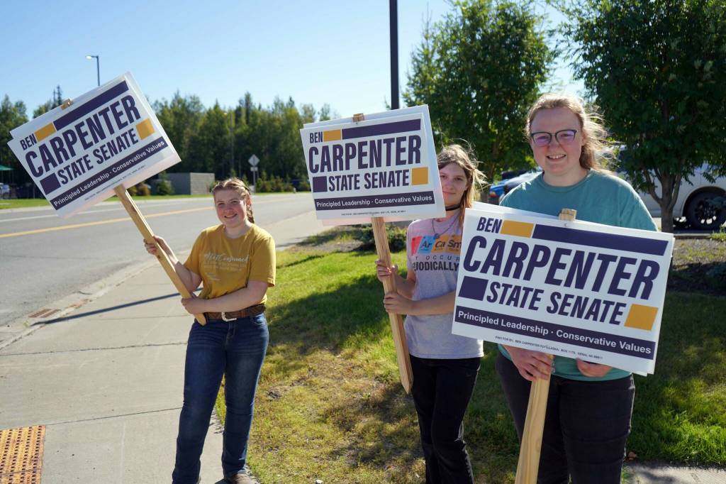 Supporters of Rep. Ben Carpenter, R-Nikiski, wave signs on the side of the Sterling Highway in Soldotna, Alaska, during the Alaska Primary Election Day on Tuesday, Aug. 20, 2024. (Jake Dye/Peninsula Clarion)