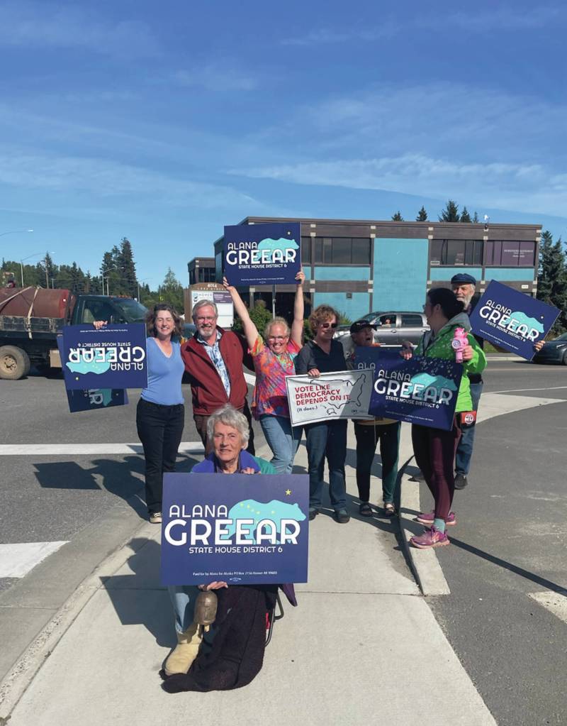 Homer residents hold political signs in support of Alaska House District 6 candidates at the corner of Pioneer Avenue and Lake Street in Homer, Alaska, on Aug. 20, 2024. ( Emilie Springer/ Homer News)
