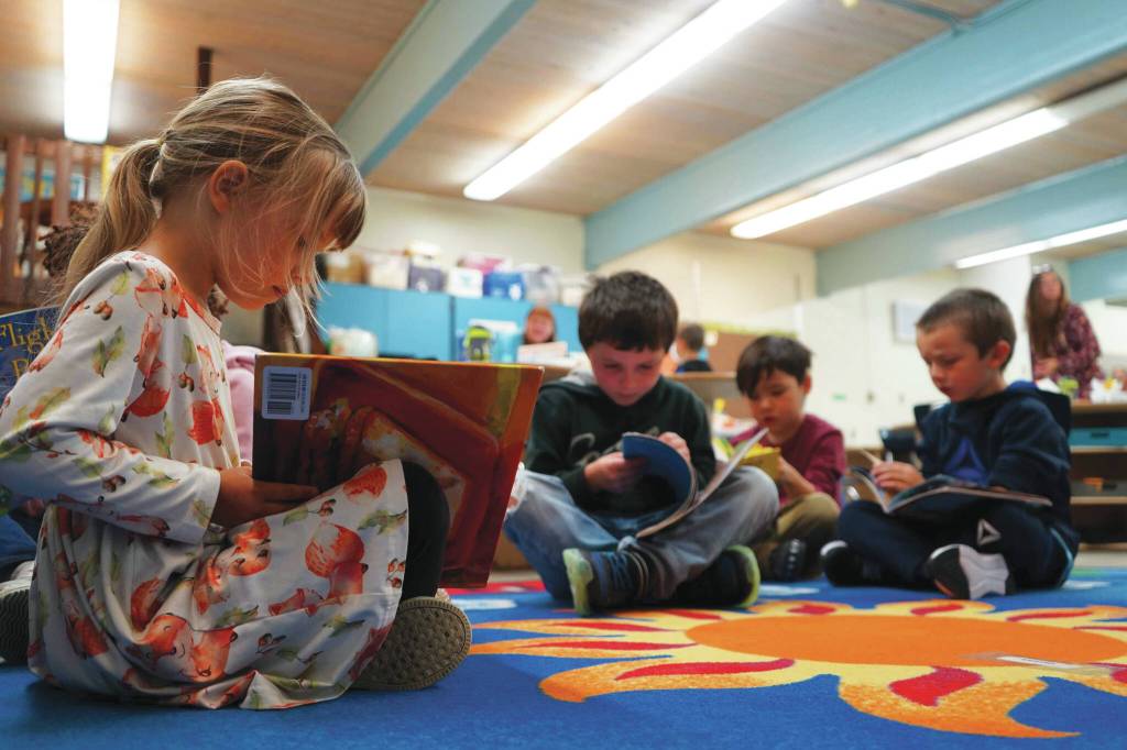 Students sit down to read books on the first day of the school year at Tustumena Elementary School in Kasilof on Wednesday. (Jake Dye/Peninsula Clarion)