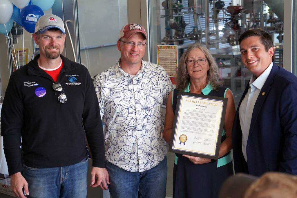 Lisa Parker, center-right, is awarded a legislative citation in recognition of her service on the University of Alaska Board of Regents by Sen. Jesse Bjorkman and Reps. Ben Carpenter and Justin Ruffridge at a celebration of the 60th anniversary of Kenai Peninsula College in Soldotna, Alaska, on Tuesday, Aug. 20, 2024. (Jake Dye/Peninsula Clarion)