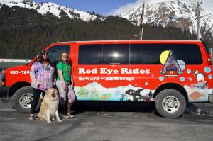 Angel Patterson-Moe and Natalie Norris stand in front of one of their Red Eye Rides vehicles in Seward, Alaska, on Wednesday, April 24, 2024. (Jake Dye/Peninsula Clarion)