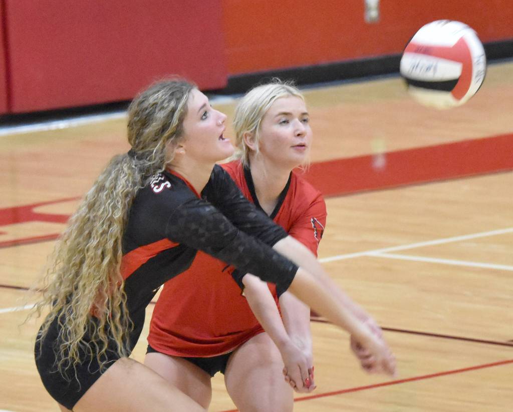 Sophie Tapley and Brynnen Hansen dig up a ball at Kenai Central High School in Kenai, Alaska, on Thursday, Aug. 29, 2024. (Photo by Jeff Helminiak/Peninsula Clarion)