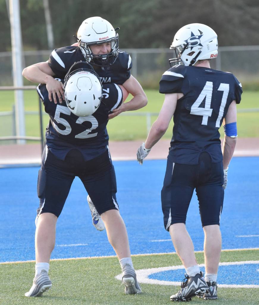 Owen Buckbee (1) celebrates his touchdown with Dalton Armstrong (52) and Chase Hall (41) on Friday, Sept. 6, 2024, at Justin Maile Field in Soldotna, Alaska. (Photo by Jeff Helminiak/Peninsula Clarion)