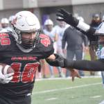 Kenai Central's Bobby Hayes runs against Chugiak's Elijah Ortega on Saturday, Sept. 7, 2024, at Ed Hollier Field at Kenai Central High School in Kenai, Alaska. (Photo by Jeff Helminiak/Peninsula Clarion)