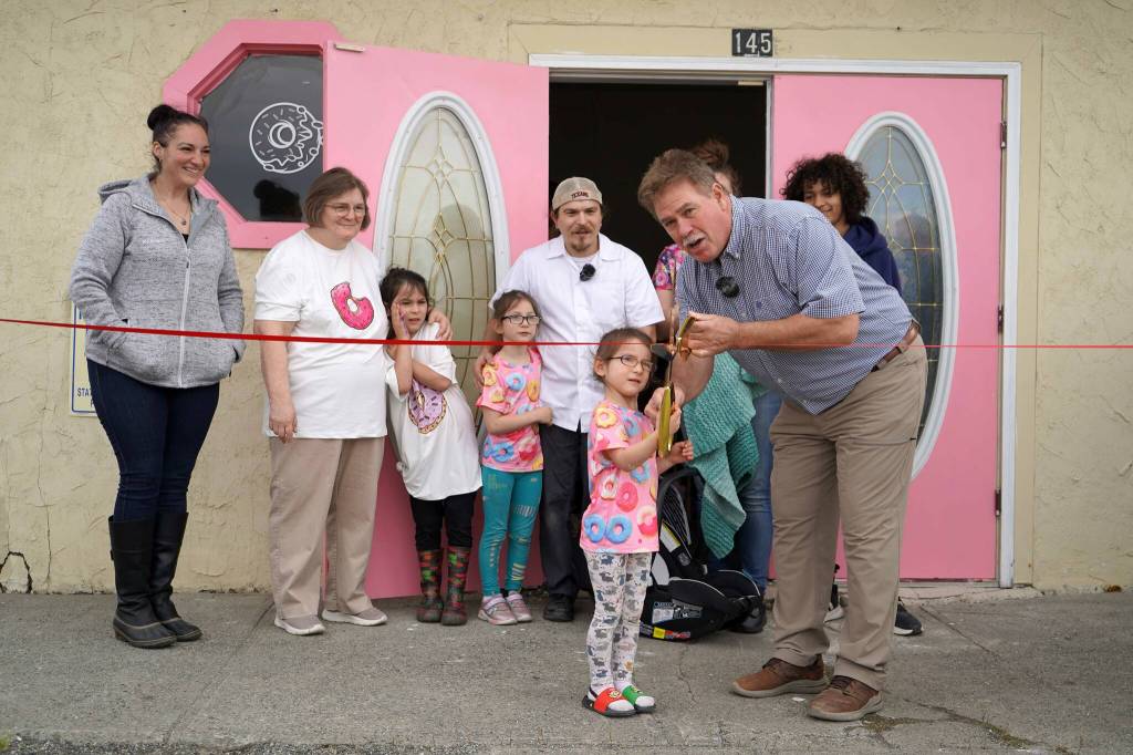 Kenai Mayor Brian Gabriel is joined by one of the children of the Gutierrez family as they cut the ribbon to open The Glaze in Kenai, Alaska, on Wednesday, Sept. 4, 2024. (Jake Dye/Peninsula Clarion)