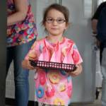 Children distribute bags of doughnut holes during a ribbon-cutting event for The Glaze in Kenai, Alaska, on Wednesday, Sept. 4, 2024. (Jake Dye/Peninsula Clarion)