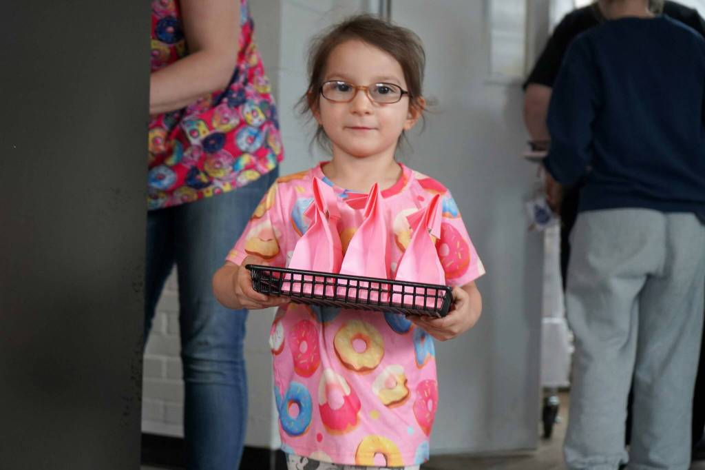 Children distribute bags of doughnut holes during a ribbon-cutting event for The Glaze in Kenai, Alaska, on Wednesday, Sept. 4, 2024. (Jake Dye/Peninsula Clarion)