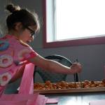 Children fill bags of doughnut holes during a ribbon-cutting event for The Glaze in Kenai, Alaska, on Wednesday, Sept. 4, 2024. (Jake Dye/Peninsula Clarion)
