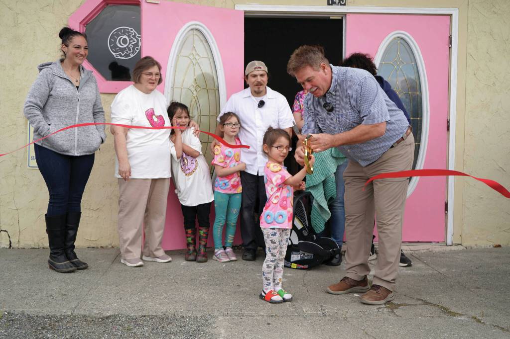 Jake Dye/Peninsula Clarion
Kenai Mayor Brian Gabriel is joined by one of the children of the Gutierrez family as they cut the ribbon to open The Glaze in Kenai on Wednesday, Sept. 4.