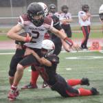 Houstons Blake Baskett is sacked by Kenai Centrals Roman Mosquito on Saturday, Sept. 14, 2024, at Ed Hollier Field at Kenai Central High School in Kenai, Alaska. (Photo by Jeff Helminiak/Peninsula Clarion)