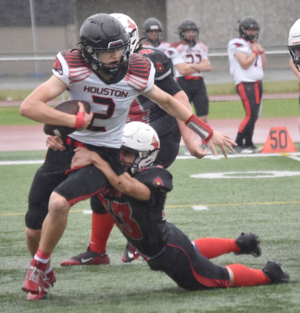 Houstons Blake Baskett is sacked by Kenai Centrals Roman Mosquito on Saturday, Sept. 14, 2024, at Ed Hollier Field at Kenai Central High School in Kenai, Alaska. (Photo by Jeff Helminiak/Peninsula Clarion)
