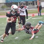Kenai Centrals Aasen Campanella runs against Houstons Terje McClurg on Saturday, Sept. 14, 2024, at Ed Hollier Field at Kenai Central High School in Kenai, Alaska. (Photo by Jeff Helminiak/Peninsula Clarion)