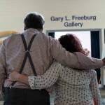 Tom Dalrymple and Brandi Kerley share an embrace before the opening of a memorial art gallery for Kenai Peninsula College Associate Professor of Art Cambid-J Cam Choy at Kenai Peninsula College in Soldotna, Alaska, on Friday, Sept. 13, 2024. (Jake Dye/Peninsula Clarion)