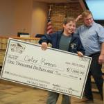 Jake Dye/Peninsula Clarion
Carter Romero is awarded a $1,000 novelty check for landing the youth grand-prize salmon in the Eighth Annual Kenai Silver Salmon Derby during a meeting of the Kenai City Council on Wednesday.