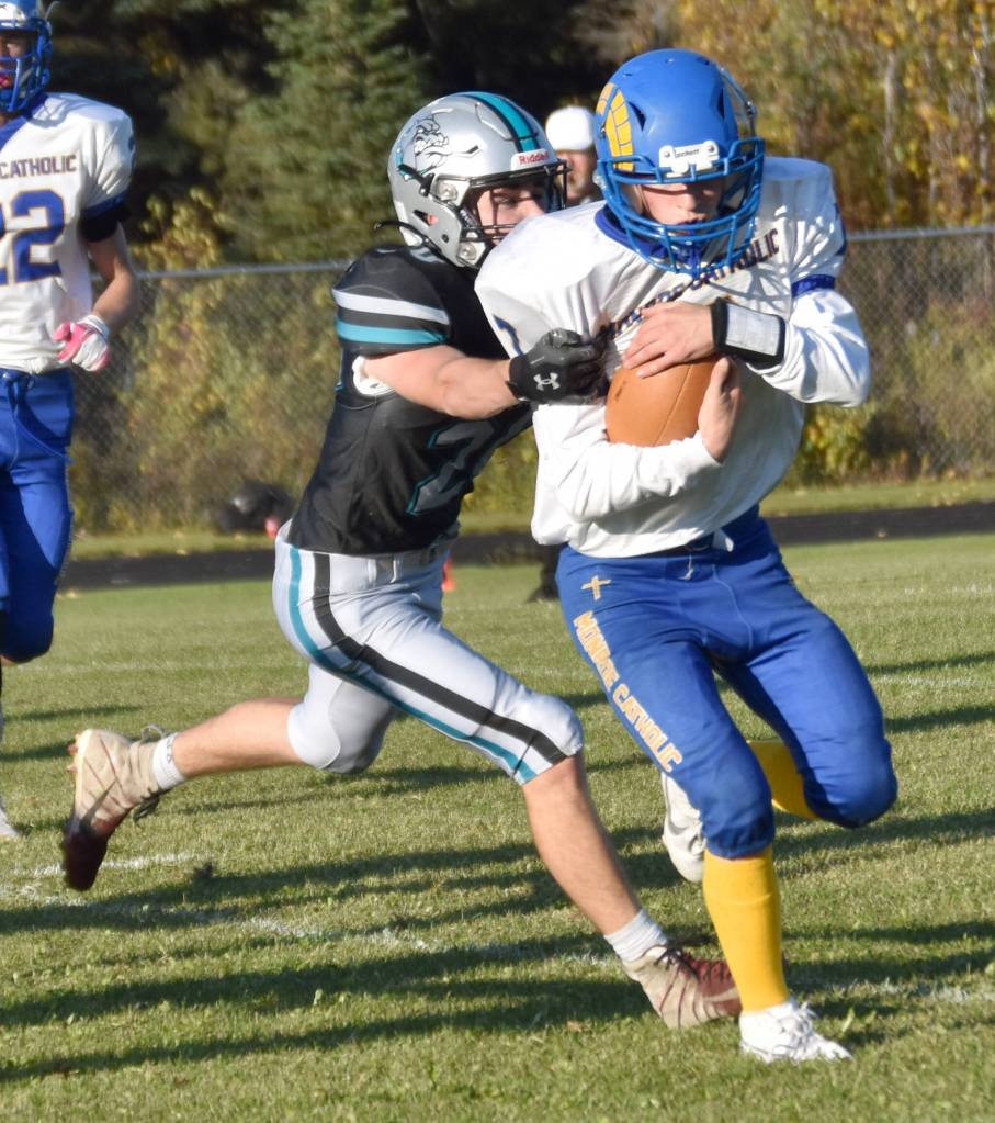 Monroe Catholic quarterback Ryan Mavencamp runs against Nikiskis Wyatt Maguire on Friday, Sept. 20, 2024, at Nikiski Middle-High School in Nikiski, Alaska. (Photo by Jeff Helminiak/Peninsula Clarion)