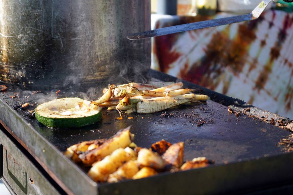 Willow King grills up some vegetables during the Harvest Moon Local Food Festival at Soldotna Creek Park in Soldotna, Alaska, on Saturday, Sept. 21, 2024. (Jake Dye/Peninsula Clarion)