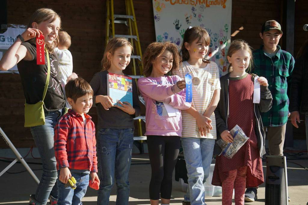 Youth winners of the Harvest Moon Local Food Festivals pie contest stand with their awards at Soldotna Creek Park in Soldotna, Alaska, on Saturday, Sept. 21, 2024. From left: second-place Jesse Fiona and Atlas Ohn-Bar; first-place Adam and Megan Johnson; and third-place Juniper Goodman. (Jake Dye/Peninsula Clarion)