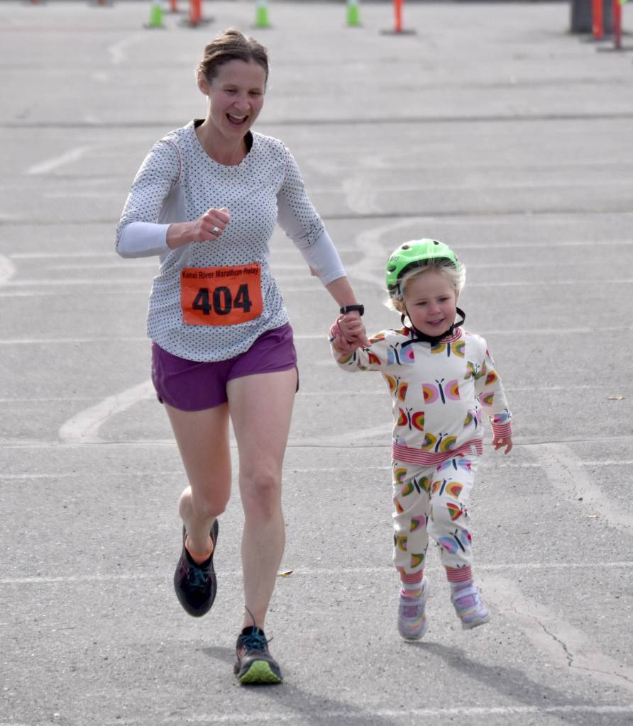 Rachel Neuendorf and her daughter, Ember, finish off a relay victory for Relay 2024 at the Kenai River Marathon on Sunday, Sept. 29, 2024, in Kenai, Alaska. (Photo by Jeff Helminiak/Peninsula Clarion)