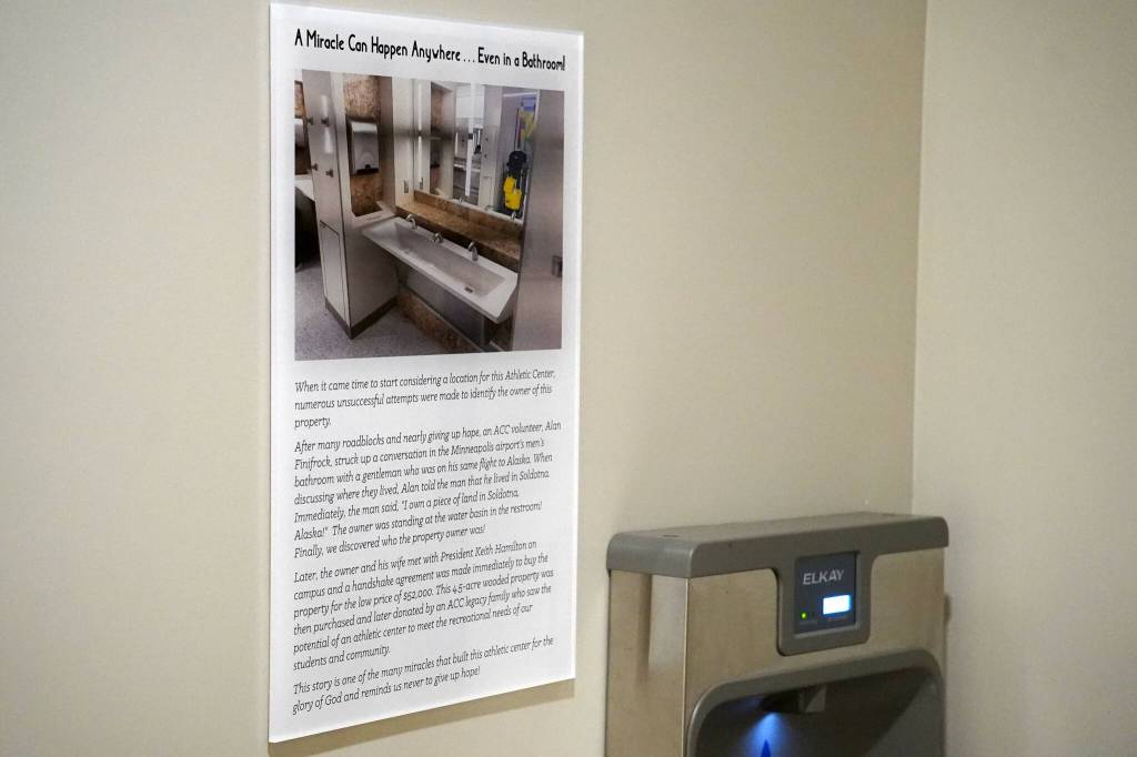 A plaque hanging outside the bathrooms of the Alaska Christian College Athletic Center describes the meeting in a Minneapolis airport bathroom that led to Alaska Christian College obtaining the land for the facility at Alaska Christian College in Soldotna, Alaska, on Friday, Sept. 27, 2024. (Jake Dye/Peninsula Clarion)