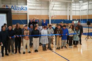 Alaska Christian College students, staff and other dignitaries gather as Styles Walker cuts the ribbon during a dedication ceremony for the colleges new athletic center at Alaska Christian College in Soldotna, Alaska, on Friday, Sept. 27, 2024. (Jake Dye/Peninsula Clarion)