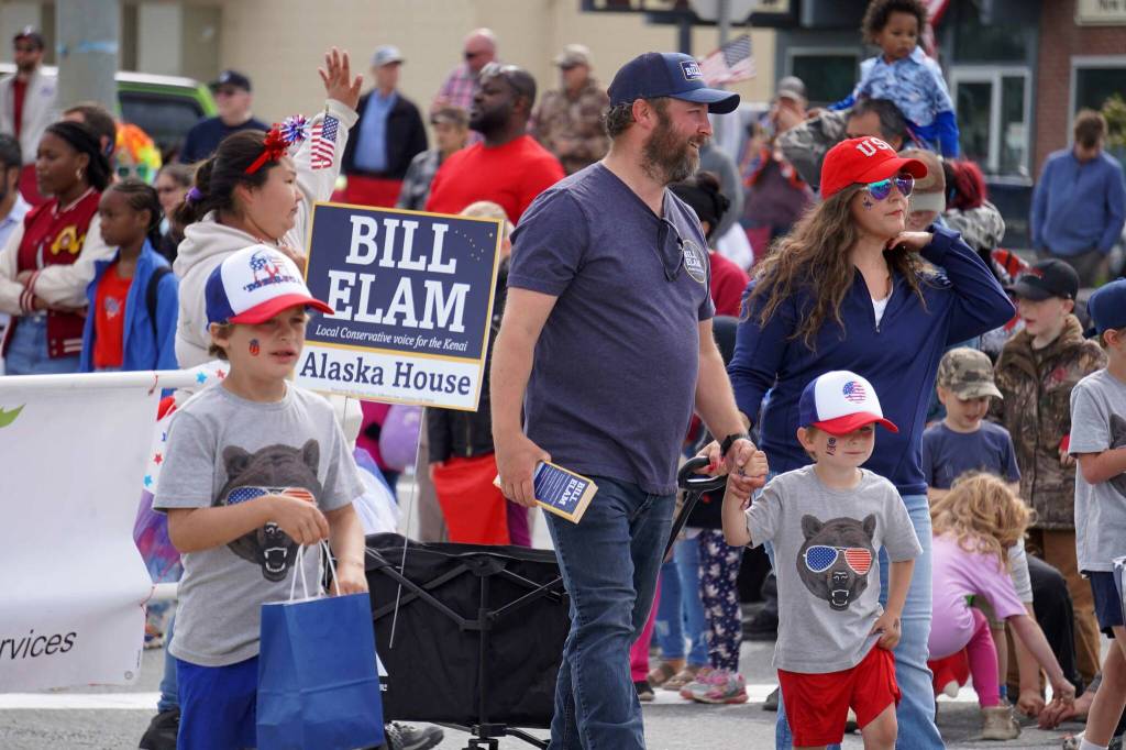 Bill Elam, candidate for the Alaska House of Representatives, walks with his family down the Kenai Spur Highway in Kenai, Alaska, during the Fourth of July Parade on Thursday, July 4, 2024. (Jake Dye/Peninsula Clarion)