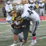 Nikiskis Jackson Wittmer and Trigger McCaughey bring down Sewards Noah Price on Friday, Oct. 11, 2024, at Justin Maile Field in Soldotna, Alaska. (Photo by Jeff Helminiak/Peninsula Clarion)
