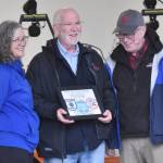 Pat King (right), chair of the Tsalteshi Trails Association Board of Directors, presents Lisa Parker of the Soldotna City Council and Soldotna Mayor Paul Whitney with a certificate of appreciation at a winter kick-off and open house event to celebrate a new trail system maintenance shed Saturday, Oct. 12, 2024, just outside of Soldotna, Alaska. (Photo by Jeff Helminiak/Peninsula Clarion)