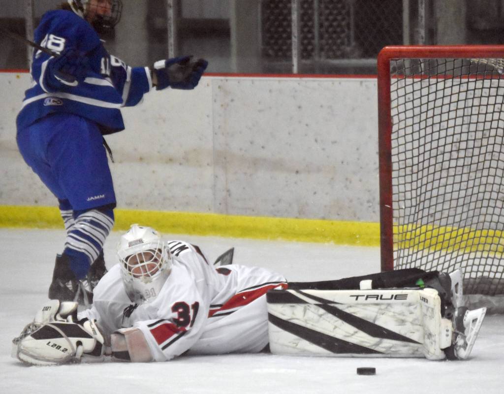 Kenai Central goalie Evyn Witt makes a save on Palmers Kinan Greco during the Peninsula Ice Challenge on Thursday, Oct. 31, 2024, at the Kenai Multi-Purpose Facility in Kenai, Alaska. (Photo by Jeff Helminiak/Peninsula Clarion)