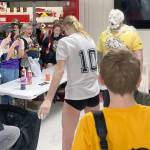 Soldotna's Cassidy Kruse hits Soldotna head coach Luke Baumer with a pie as part of the Killing Cancer on the Kenai event on Friday, Nov. 1, 2024, at Kenai Central High School in Kenai, Alaska. (Photo by Jeff Helminiak/Peninsula Clarion)