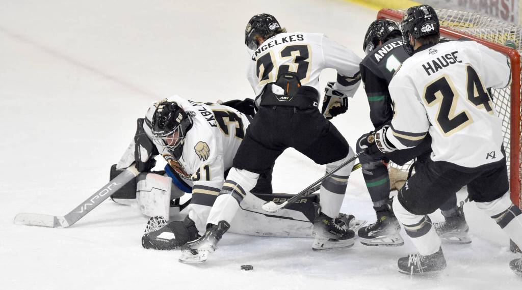 Kenai River Brown Bears goalie Leif Ekblad moves to cover the puck while teammates Brady Engelkes and Luke Hause try to keep Avery Anderson of the Minnesota Wilderness from scoring Saturday, Nov. 2, 2024, at the Soldotna Regional Sports Complex in Soldotna, Alaska. (Photo by Jeff Helminiak/Peninsula Clarion)