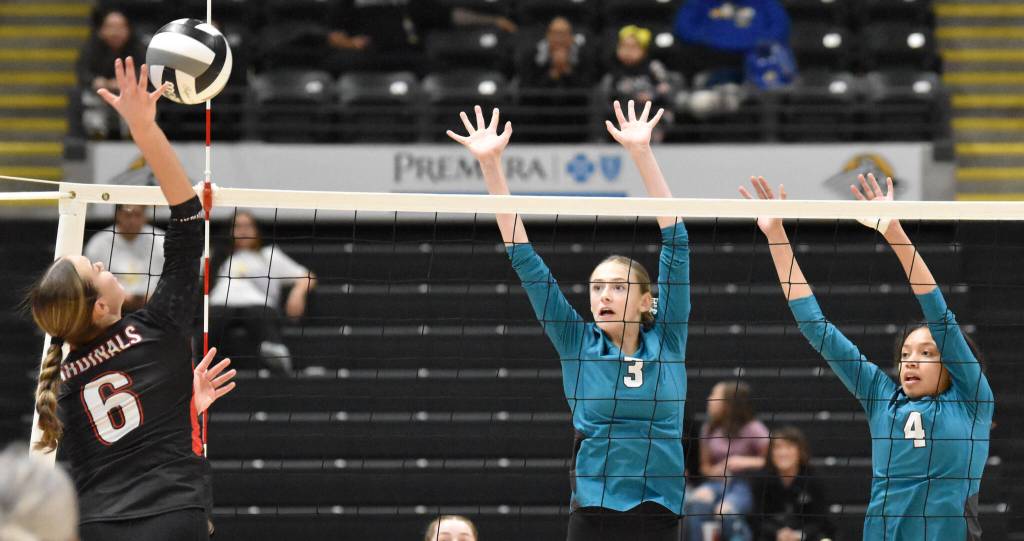 Kenai Centrals Stella Selanoff hits against Nikiskis Blakeley Jorgensen and Alexa Iyatunguk on Saturday, Nov. 16, 2024, in the Class 3A state volleyball championship at the Alaska Airlines Center in Anchorage, Alaska. (Photo by Jeff Helminiak/Peninsula Clarion)
