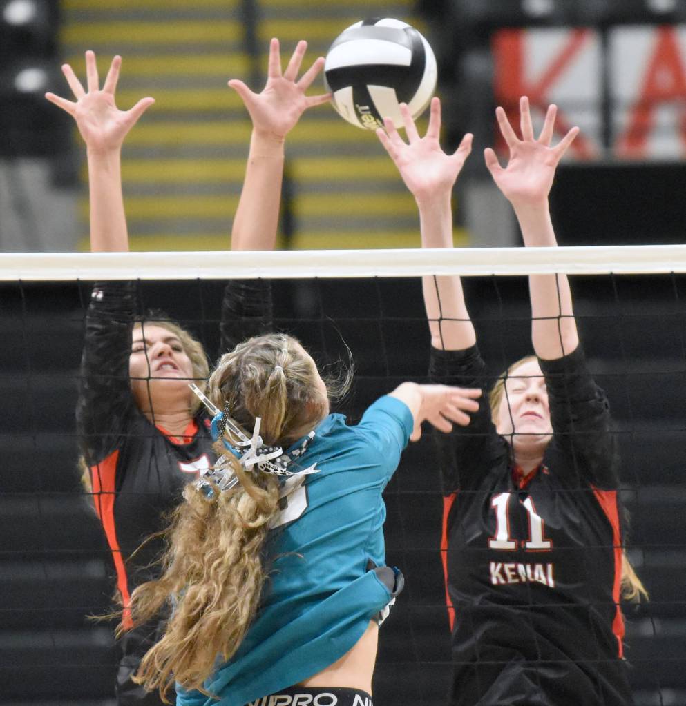 Kenai Centrals Sophie Tapley and Ellsi Miller put up a block on Nikiskis Blakeley Jorgensen on Saturday, Nov. 16, 2024, in the Class 3A state volleyball championship at the Alaska Airlines Center in Anchorage, Alaska. (Photo by Jeff Helminiak/Peninsula Clarion)