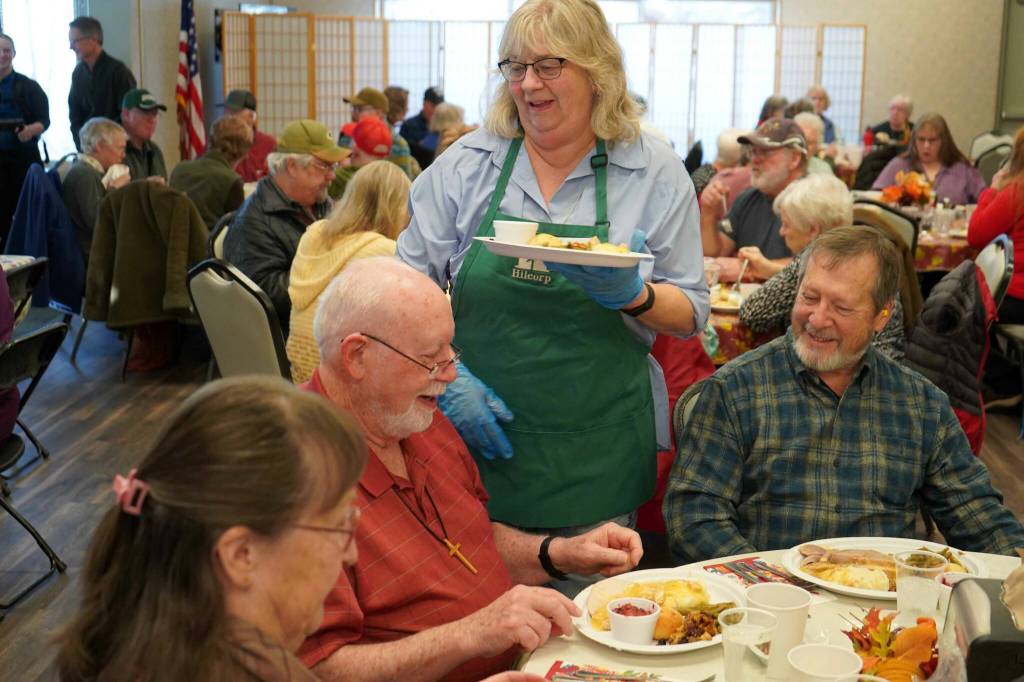 Kenai City Council member and Hilcorp volunteer Victoria Askin delivers Thanksgiving meals during the Hilcorp Areawide Senior Thanksgiving Luncheon in the Kenai Senior Center banquet hall in Kenai, Alaska, on Friday, Nov. 22, 2024. (Jake Dye/Peninsula Clarion)