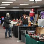 Henry Dera, of Crooked Creek Birch, chats with shoppers at the 33rd Annual Holiday Bazaar at the Soldotna Regional Sports Complex in Soldotna, Alaska, on Friday, Nov. 22, 2024. (Jonas Oyoumick/Peninsula Clarion)