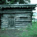 Photo by Clark Fair, 1985
The log shed at Blakes Place on the north shore on Tustumena Lake, near the outlet of Indian Creek. Kerri Dolph holed up here for several days after the death of her husband, John.