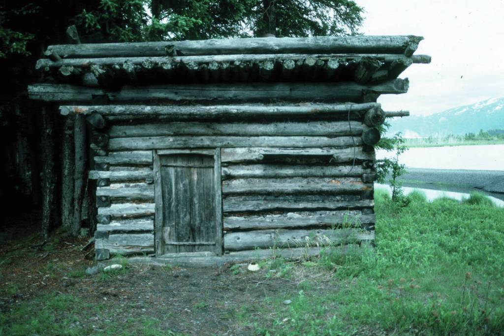 The log shed at Blakes Place on the north shore on Tustumena Lake, near the outlet of Indian Creek. Kerri Dolph holed up here for several days after the death of her husband John. (Photo by Clark Fair, 1985)