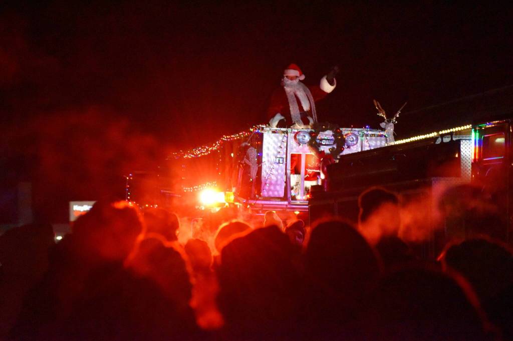Santa Claus waves from atop a Kenai Fire Department engine during the Electric Lights Parade on Frontage Street in Kenai, Alaska, on Friday, Nov. 29, 2024. (Jonas Oyoumick/Peninsula Clarion)